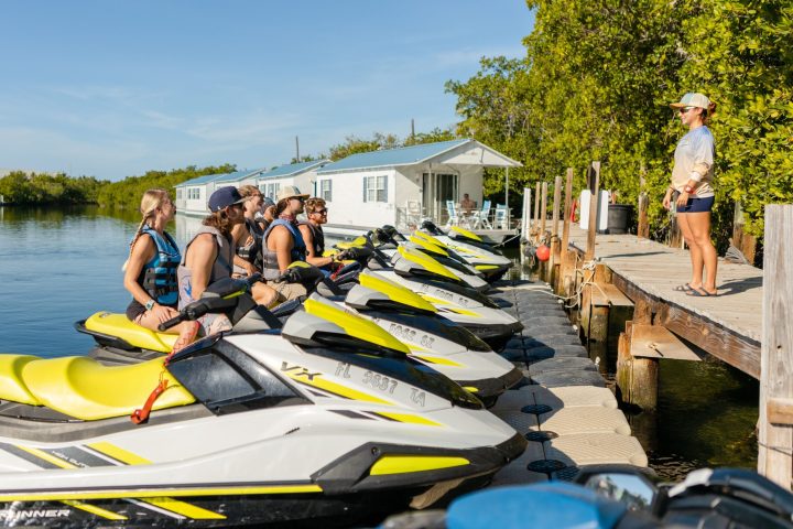 A group of people on jetskis with instructor.