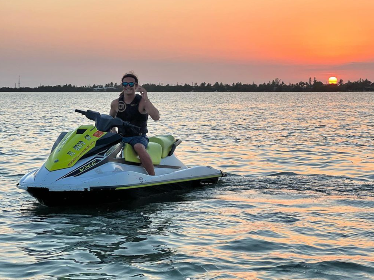 a man riding on the back of a boat in a body of water